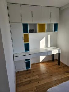 Habitación con escritorio blanco y suelo de madera. en 3 Zimmer Wohnung, en Maria Lanzendorf