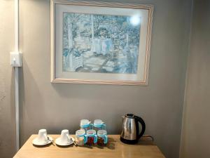 una mesa con cafetera y una foto en la pared en Mitchell Guesthouse, en Pietermaritzburg