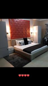 1 dormitorio con 1 cama grande y cabecero rojo en HOLIDAY Staycation, en Pekayon Dua