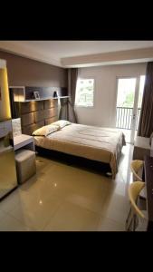 Un dormitorio con una cama grande y una ventana en HOLIDAY Staycation, en Pekayon Dua