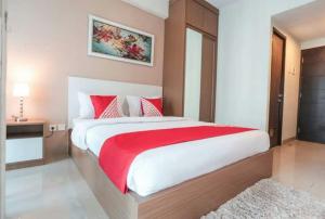 1 dormitorio con 1 cama grande con manta roja en HOLIDAY Staycation, en Pekayon Dua