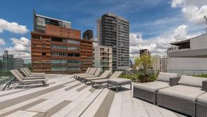 a rooftop with chairs and tables on a building at Studio completo próx. estação Fradique Coutinho in Sao Paulo