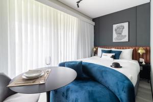 1 dormitorio con 1 cama con sofá azul y mesa en Iconyc Charlie Hotel São Paulo - Soft Opening en São Paulo