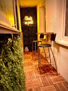 two chairs and a table in front of a bar at Apartamenty Cześć Kraków in Krakow