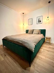 1 dormitorio con 1 cama verde en una habitación en Apartamenty Cześć Kraków en Cracovia
