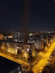 una città di notte con edifici e luci di Apartamenty Cześć Kraków a Cracovia