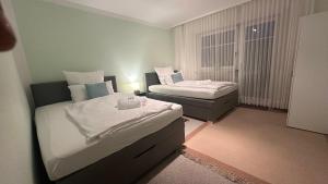 une chambre d'hôtel avec deux lits et une fenêtre dans l'établissement Oase1 mit Parkplatz, Automatische Kaffeemaschine und Küche, à Untermeitingen