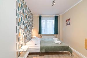 Schlafzimmer mit einem Bett und einem Fenster in der Unterkunft Willa LTC Apartments Orłowo in Gdynia