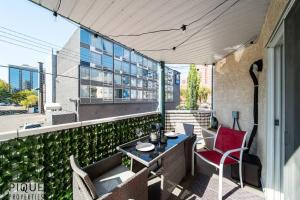 een patio met een tafel en stoelen op een balkon bij The Breakfast Club Suite - King Bed & AC - Patio - UG Park in Edmonton