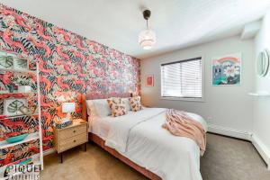 a bedroom with a large bed and a colorful wall at The Breakfast Club Suite - King Bed & AC - Patio - UG Park in Edmonton