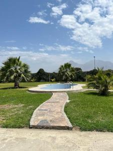 a pathway leading to a swimming pool in a park at Casa de Campo en Conache in Trujillo