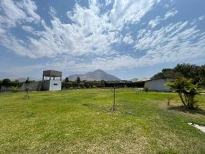 a field with a gazebo with a mountain in the background at Casa de Campo en Conache in Trujillo