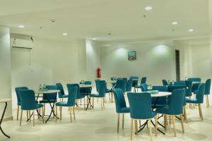 un comedor con mesas y sillas azules en فندق سيف بلص من سما en La Meca