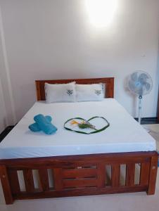 1 cama con marco de madera y colchón blanco en Meepe Huis, en Belikolapagoda