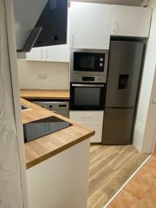 cocina con nevera negra y microondas en Piso delante de la playa La Pineda con 2 habitaciones, en La Pineda