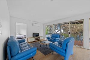 a living room with two blue chairs and a television at Sandy Point Beach Escape 2 Bedroom Apartment in Sandy Point