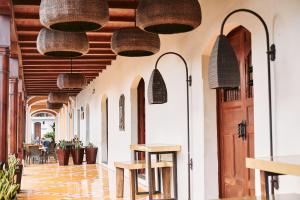 un pasillo de un restaurante con cestas colgando del techo en Hotel Plaza Colon - Granada Nicaragua en Granada