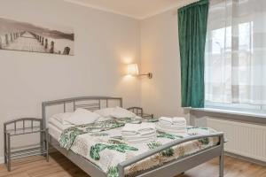 sypialnia z łóżkiem z zieloną zasłoną w obiekcie Willa LTC Apartments Orłowo w mieście Gdynia