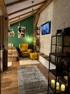 salon z łóżkiem i żółtym krzesłem w obiekcie Studio Rezistenta w Fogaraszu