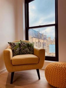a chair sitting in a room with a window at Spacious 3 Bed City Apartment with Terrace in London