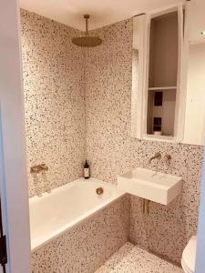 a bathroom with a bath tub and a sink at Spacious 3 Bed City Apartment with Terrace in London