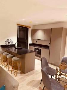 a kitchen with a counter and stools in a room at Spacious 3 Bed City Apartment with Terrace in London