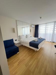 a bedroom with a large bed and a blue couch at Orbi city - Premium Class Rooms in Batumi