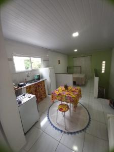 a kitchen with a table in the middle of a room at Hospedagem da Lu in Paraty