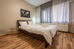 Un dormitorio con una cama grande y una ventana. en Άνετο κεντρικό διαμέρισμα., en Larisa