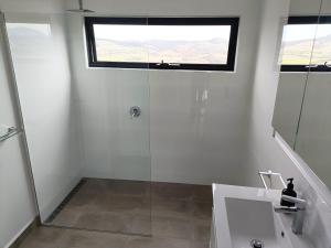 a bathroom with a shower and a sink and a window at Fingerpost Hill Farm Stay in Campania +12 photos