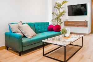 a living room with a blue couch and a table at Luxury Apartment estilo Berlin, de estreno in Guayaquil
