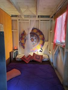 Habitación con cama morada en una casa en Mi pequeño Santuario en La Pedrera