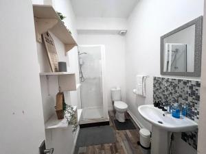 a white bathroom with a sink and a toilet at Yeovil Apartments in Yeovil