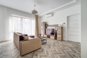 cohost I New Bastėja Life Apartments w-Garage Prkg & Self Check-in في فيلنيوس: غرفة معيشة مع أريكة وتلفزيون