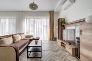 ヴィリニュスにあるcohost I New Bastėja Life Apartments w-Garage Prkg & Self Check-inのリビングルーム(ソファ、薄型テレビ付)