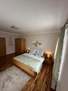 - une chambre avec un grand lit et deux lampes dans l'établissement Ferienwohnung Wolkenstein, à Wörschach
