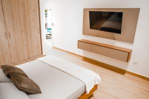 a bedroom with a bed and a tv on a wall at Luxury Apartment estilo Berlin, de estreno in Guayaquil