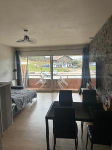 a living room with a dining table and a large window at Metabief- Front de piste in Métabief