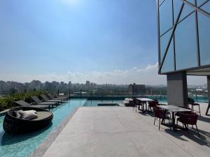 圣保罗Iconyc Charlie Ibirapuera Hotel的大楼内一个带桌椅的游泳池