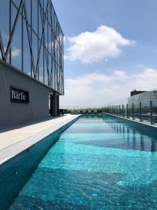 une grande piscine en face d'un bâtiment dans l'établissement Iconyc Charlie Hotel São Paulo - Soft Opening, à São Paulo