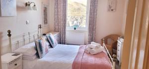 a small bedroom with a bed and a window at Ferndene Guest House in Keswick