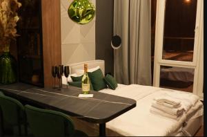 a table with a bottle of wine on top of it at Luxury apartment with jacuzzi Pechersk Plaza in Kyiv