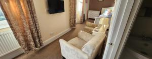 a living room with a couch and a television at Ferndene Guest House in Keswick