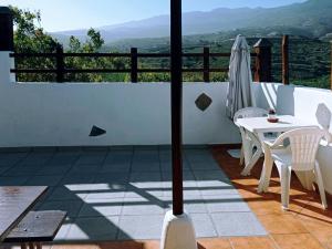 una mesa y sillas en un balcón con vistas en Live Arico El Cortijo Casa rural con Solarium & Terrace, en Arico Viejo
