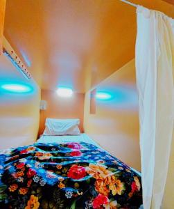 1 dormitorio con 1 cama con manta de flores en Modern Hostel Dubai en Dubái