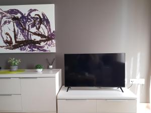 a white entertainment center with a flat screen tv at Sunny place. in Guardamar del Segura