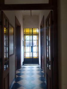 un corridoio vuoto con porte e pavimento piastrellato di Habitaciones en Casa Céntrica cerca de todo a Colonia del Sacramento
