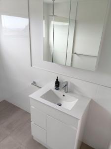 a white bathroom with a sink and a mirror at Fingerpost Hill Farm Stay in Campania