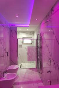 une salle de bains pourpre avec toilettes et lavabo. dans l'établissement porto, à Grado