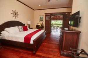a bedroom with a bed and a flat screen tv at Hotel Plaza Colon - Granada Nicaragua in Granada